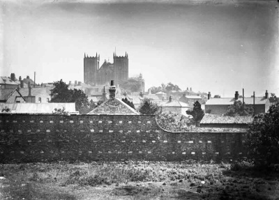 Ripon Cathedral over a brick wall and houses