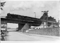 Steam train on bridge, by North Bridge Garage